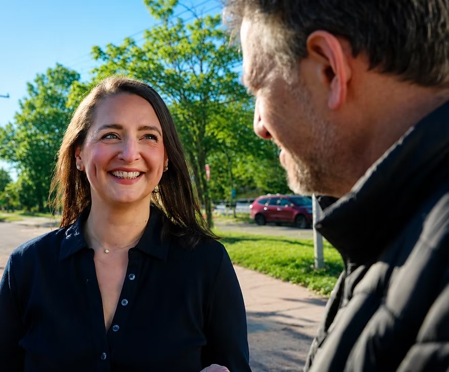 Ellen Paul talking with a resident on a neighborhood sidewalk